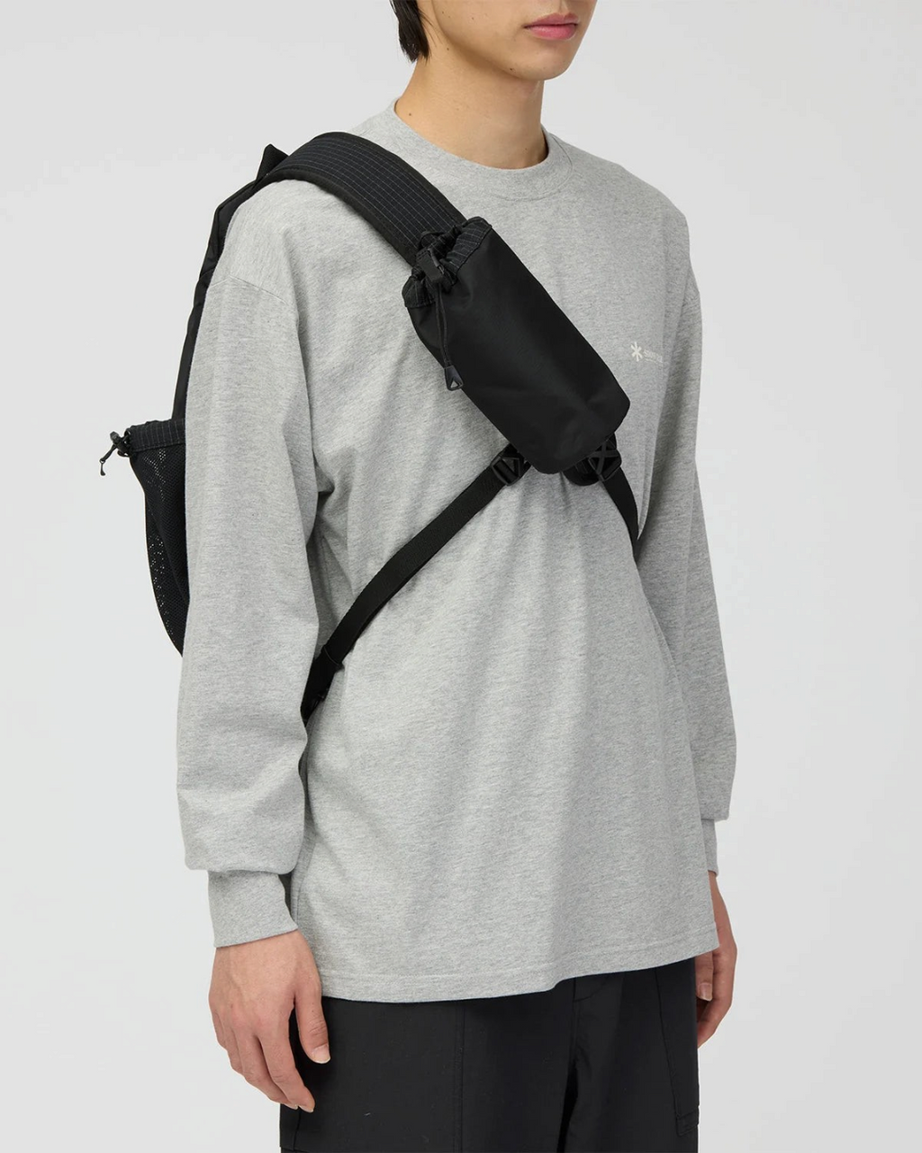 Sac bandoulière noir Merci Paris Snow Peak en tissu ripstop avec pochette amovible porté par un homme