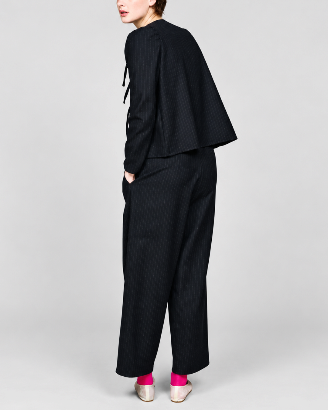 Modèle portant la chemise noire à rayures tennis ELEPH avec fermeture à nœuds et épaules froncées chez Merci Paris