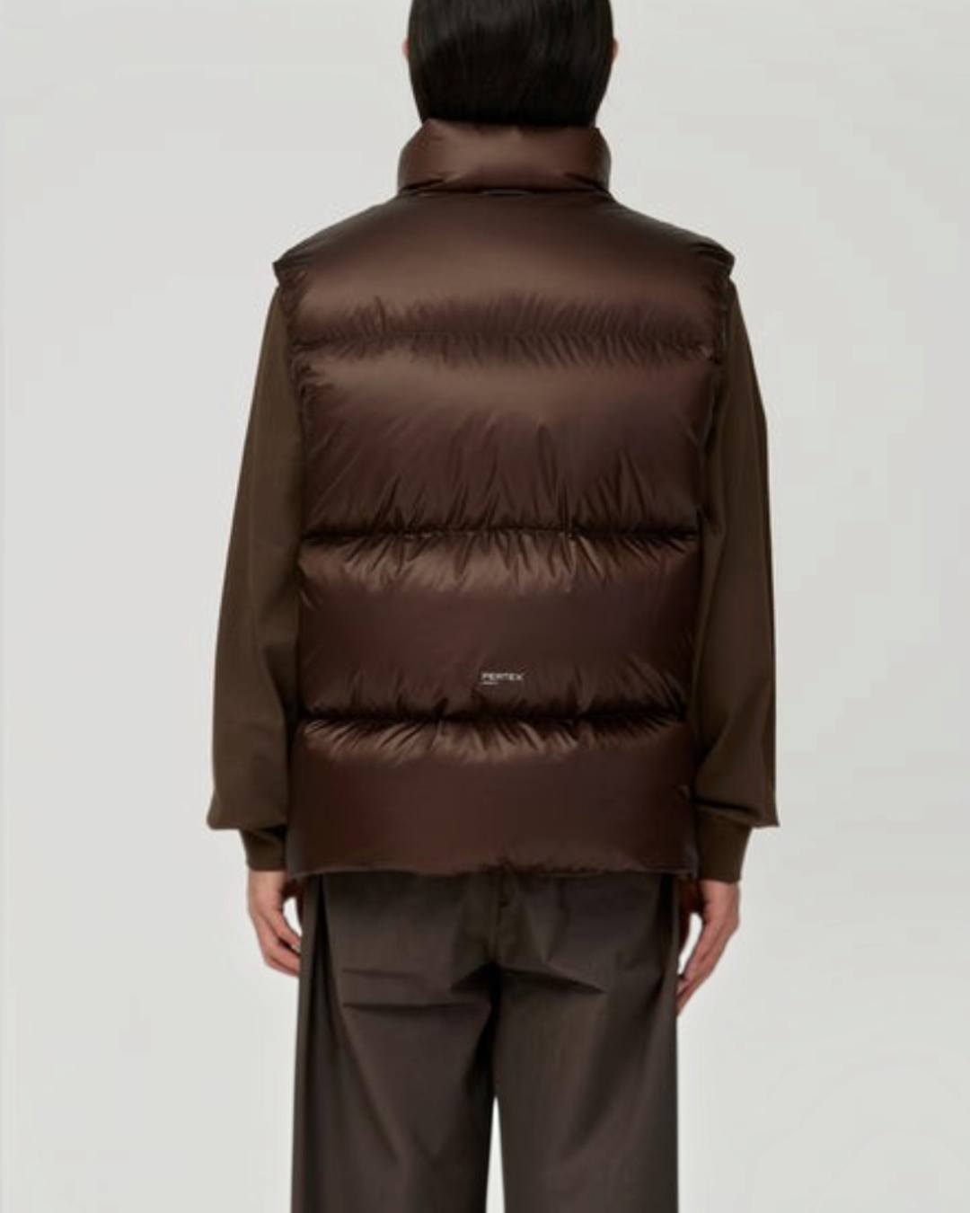 Vue arrière d'une veste sans manches Merci Paris Snow Peak en nylon marron foncé avec garnissage en duvet isolant