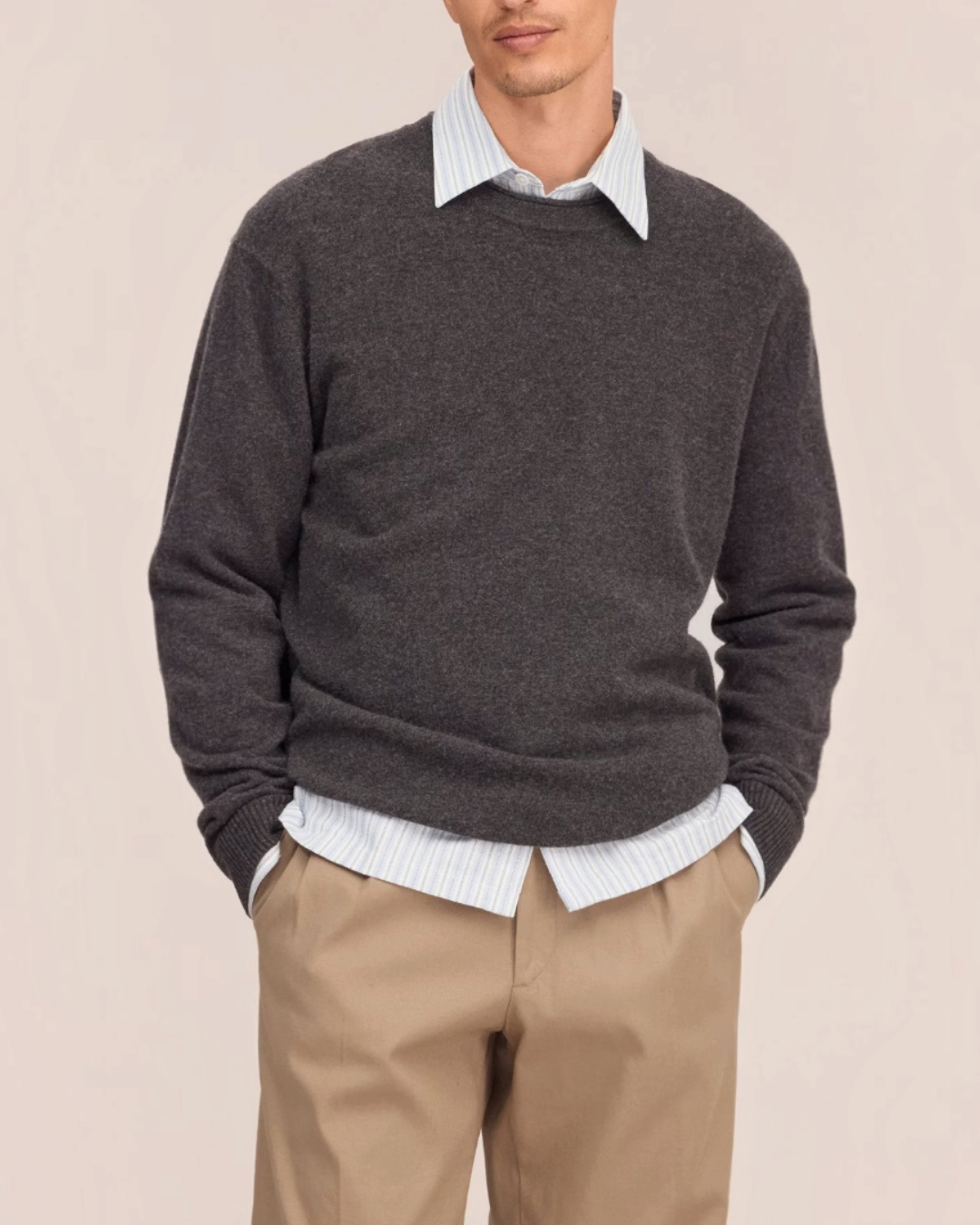 Homme portant un pull gris en laine NN.07 de Merci Paris avec col rond et bords roulottés sur une chemise rayée