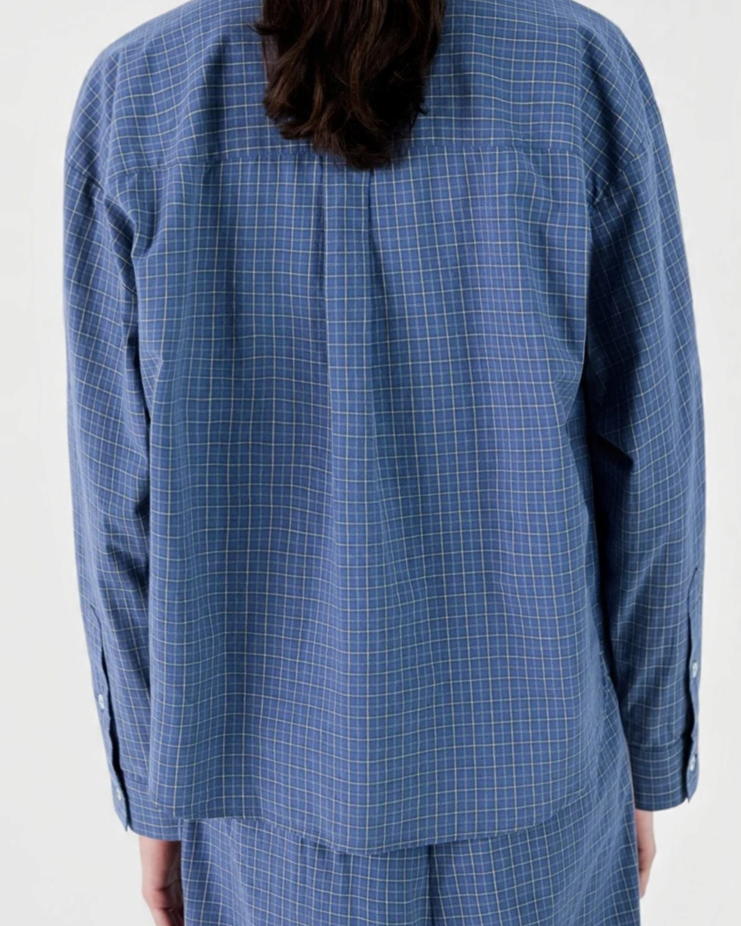 Vue de dos d'une chemise Merci Paris à carreaux bleus, coupe ample et décontractée portée par un mannequin.