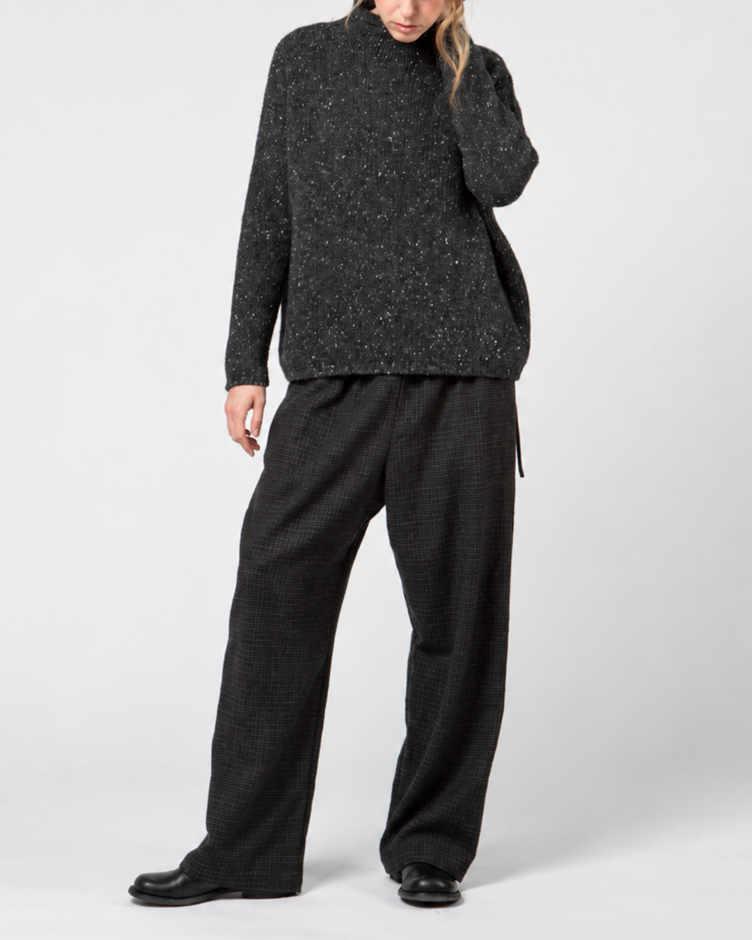 Modèle portant un pantalon large Merci Paris Apuntob bleu marine en laine à carreaux discrets et coupe fluide