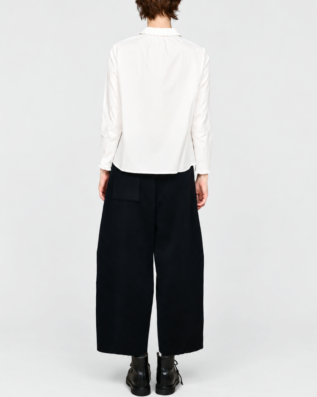 Vue arrière de la chemise blanche ELEPH Happy en coton avec col volanté, portée par une femme sur fond neutre