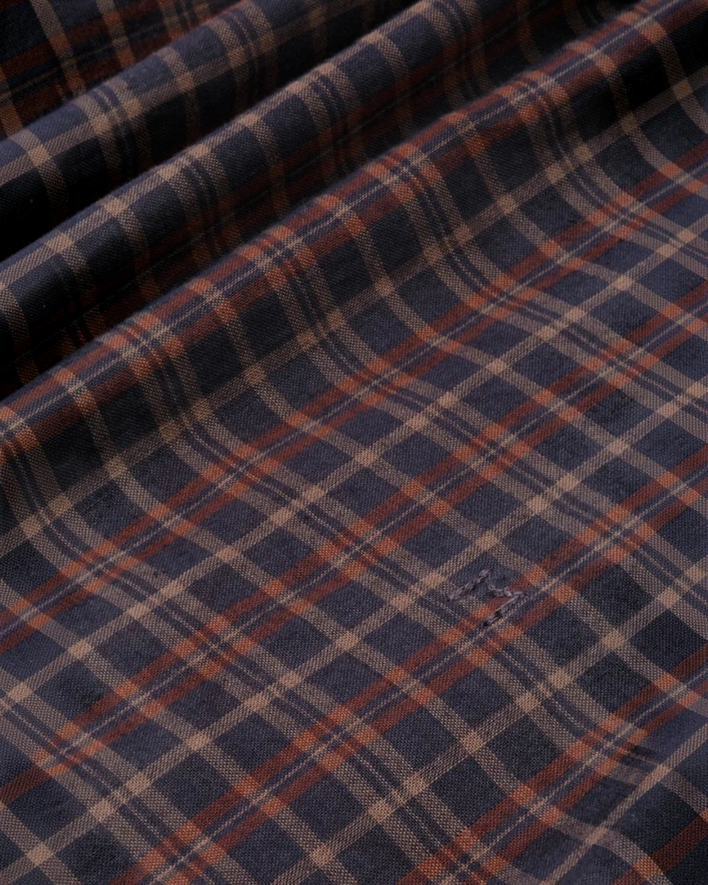 Gros plan sur le tissu en voile de coton à carreaux bleu et marron de la blouse Carmen Moismont chez Merci Paris