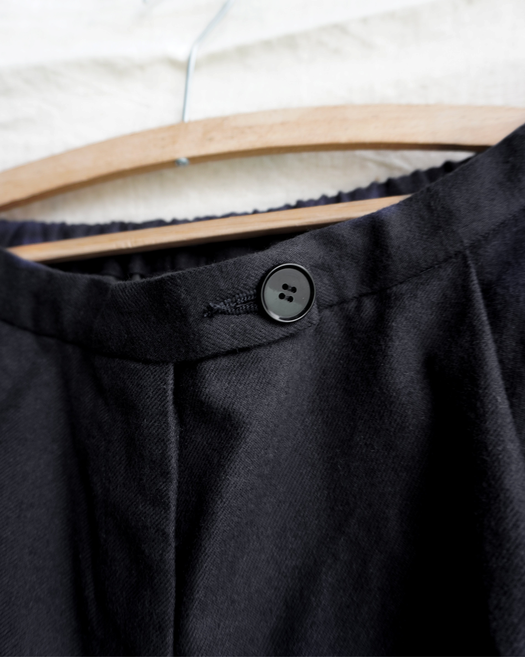 Gros plan sur la taille du pantalon gris Merci Paris Dopple & Scent avec bouton noir et ceinture élastiquée