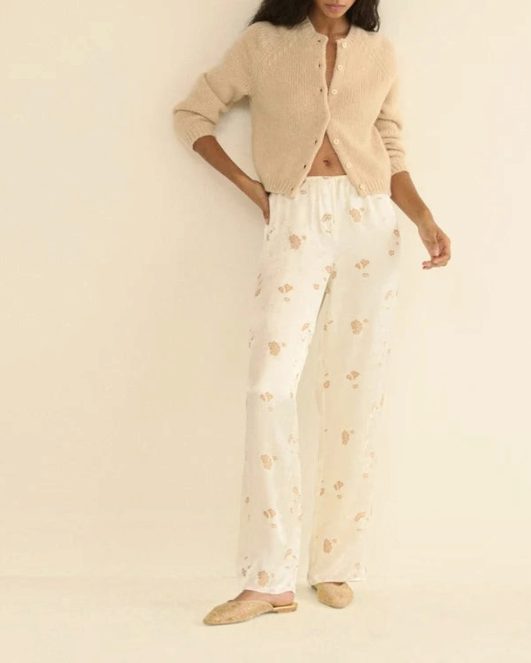 Cardigan Darcy beige en laine et cachemire Merci Paris porté par une femme avec un pantalon fluide à motifs
