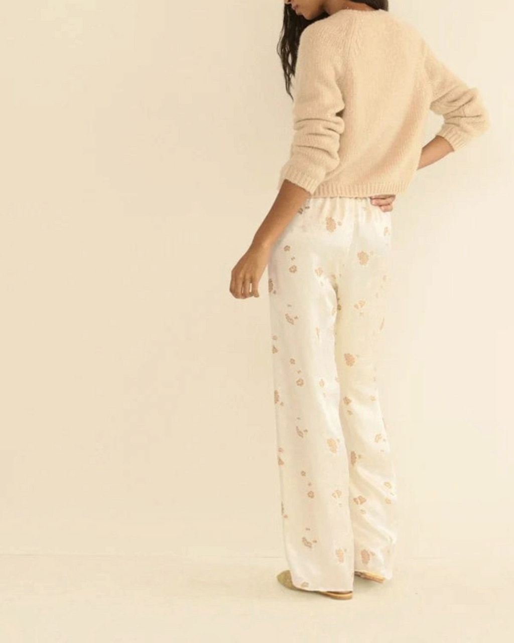 Cardigan Darcy beige en laine et cachemire Merci Paris porté par une femme avec un pantalon fluide à motifs