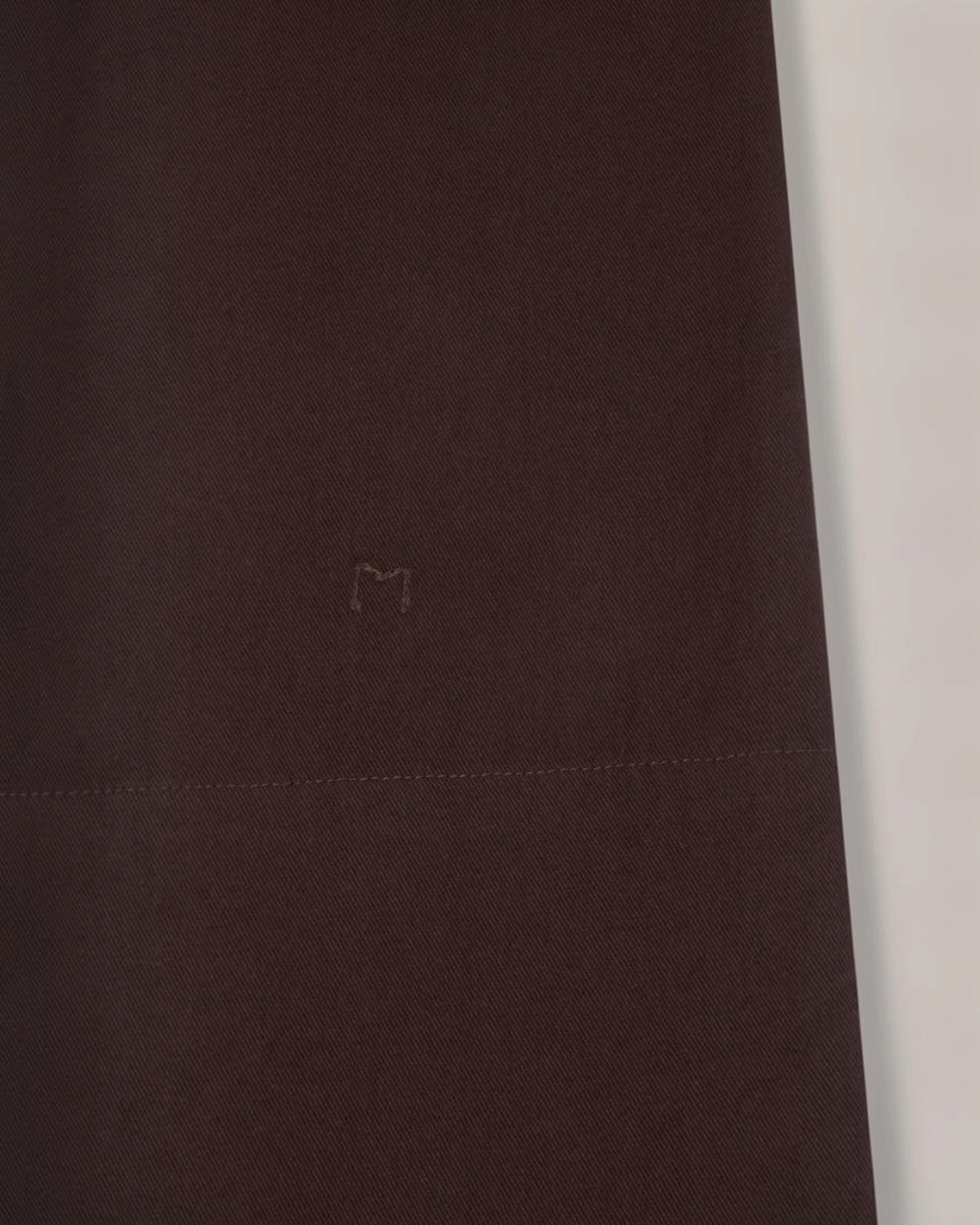 Gros plan sur la jupe Paule Merci Paris en twill de coton marron avec broderie M signature