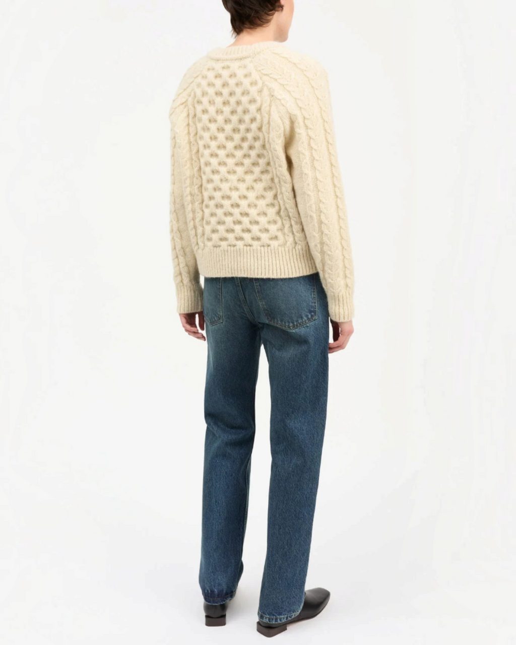 Pull Lennox blanc en laine à maille torsadée Merci Paris porté de dos avec un jean bleu