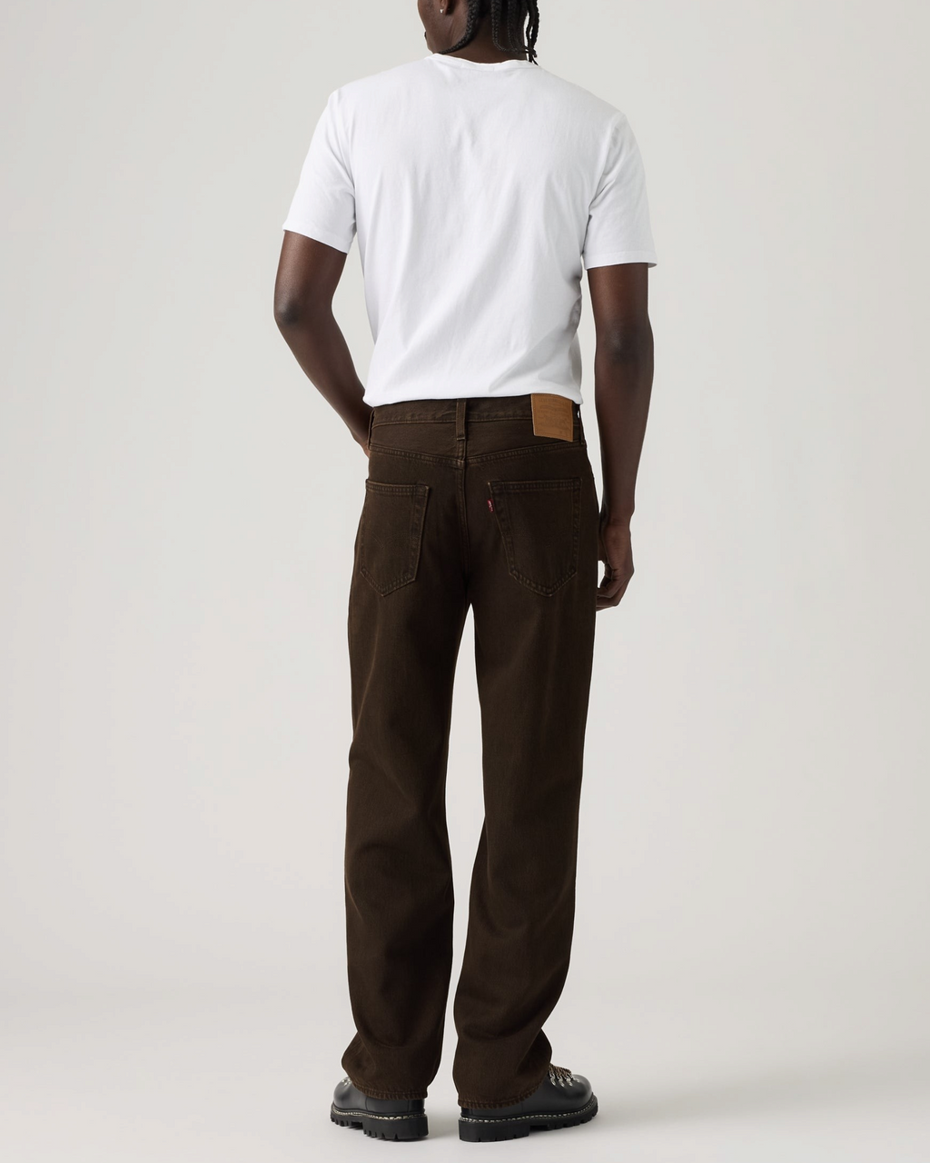 Homme portant un jean Levi's 568 Loose Straight marron en coton avec un t-shirt blanc, vue de dos, style décontracté.
