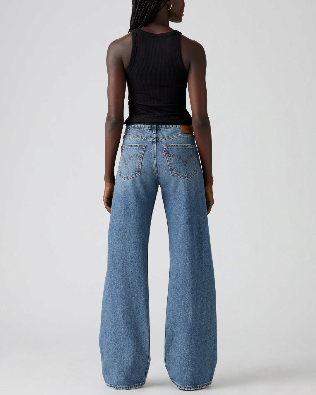 Vue arrière du jean Levi's Low Loose bleu par Merci Paris porté par une femme avec un débardeur noir