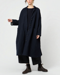 Manteau long bleu extra-ample Merci Paris par Apuntob avec col chemise et grandes poches plaquées porté par un mannequin