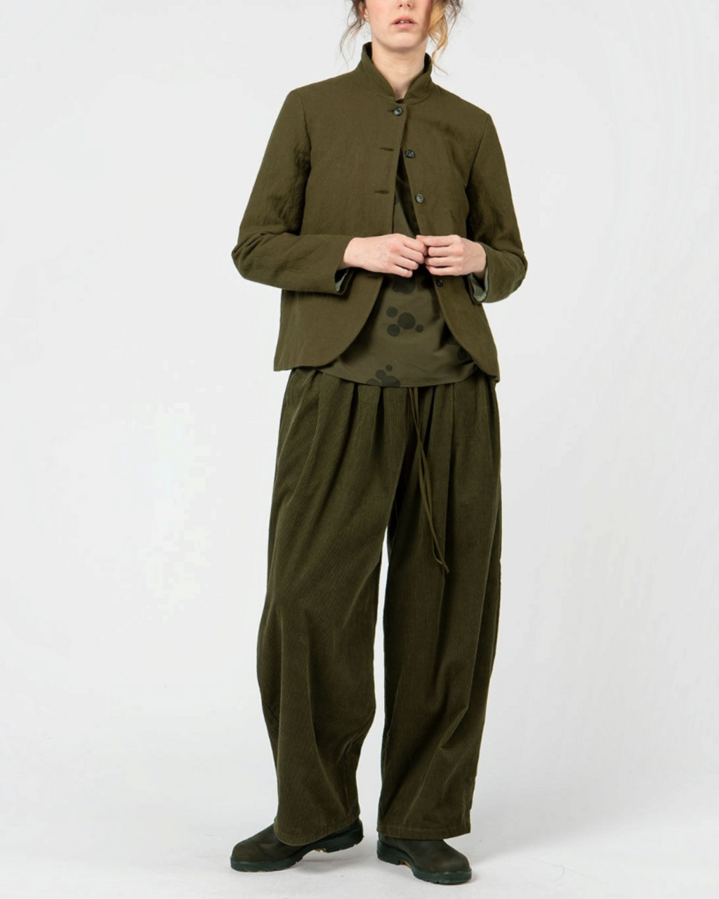 Modèle portant une veste courte Merci Paris Apuntob vert militaire à col montant et boutons ton sur ton