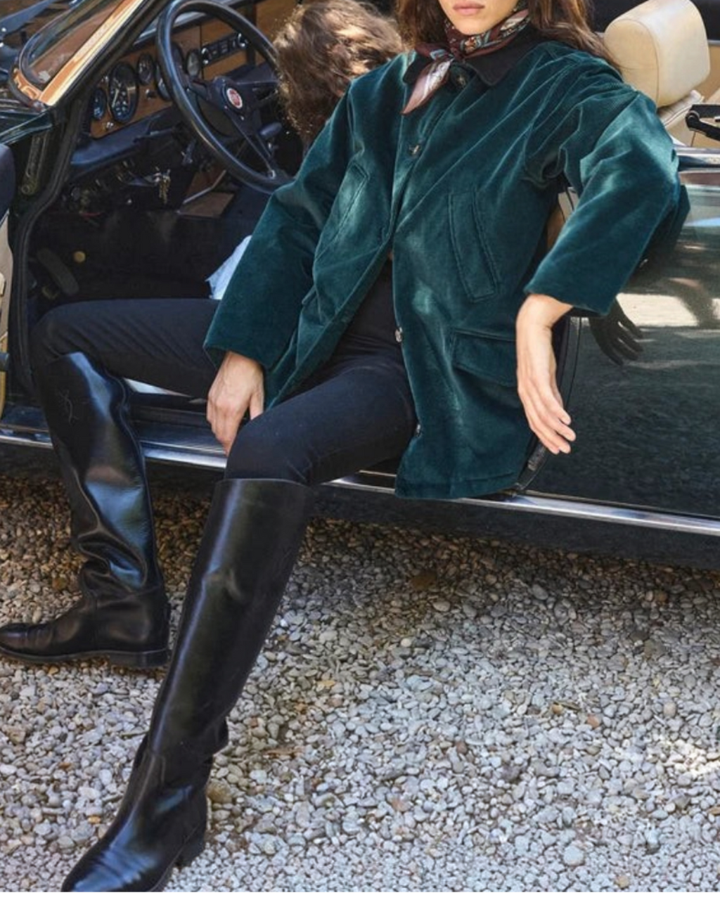 Woman wearing Pemberton jacket Merci Paris in green corduroy with suede collar, seated in a convertible car