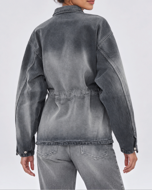 Rear view of Legacy Haikure shirt in washed gray denim with adjustable gathered back, worn by a woman